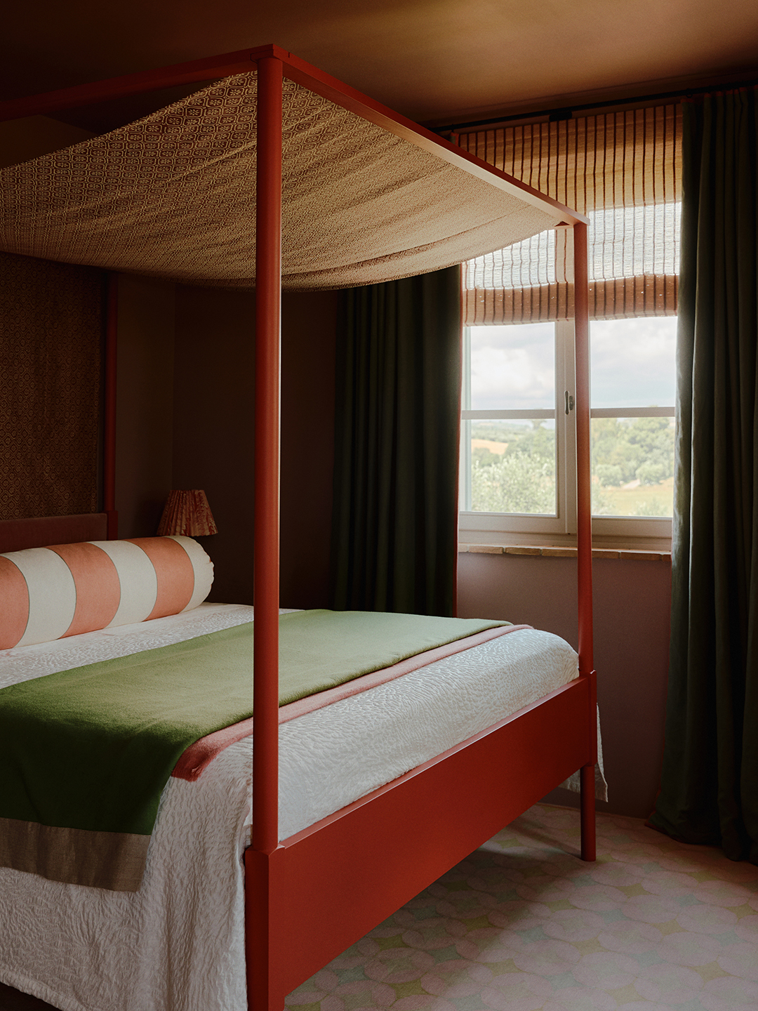 Guest room with red four poster bed