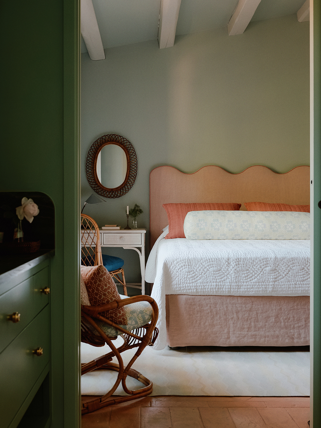 Guest bedroom with green walls and peach bed