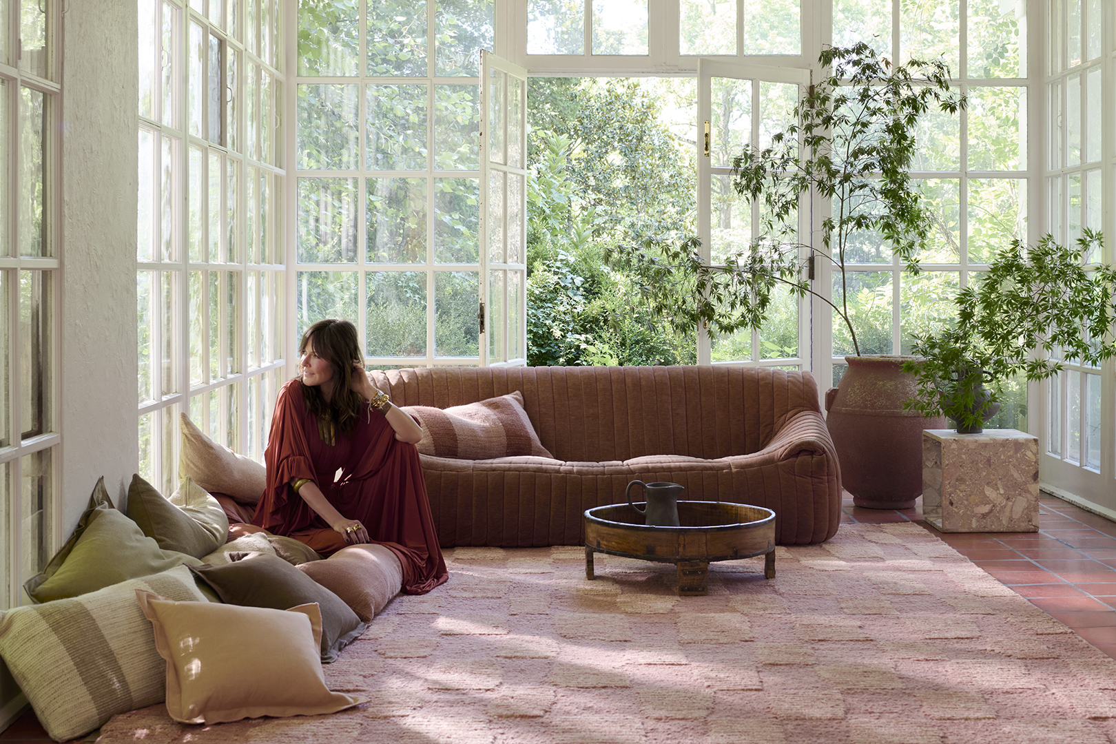 woman sitting on pink rug