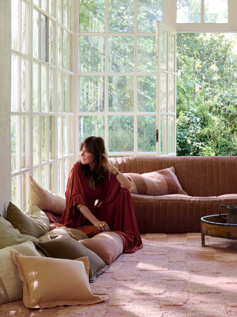 woman sitting on pink rug