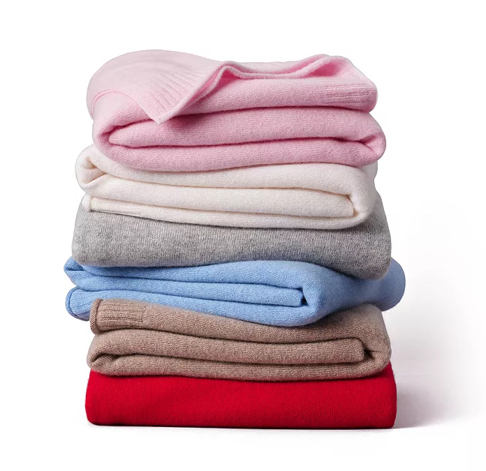  Stack of colorful cashmere blankets against white background.