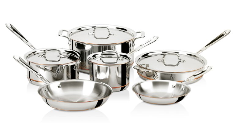  Set of stainless steel cookware against white background.