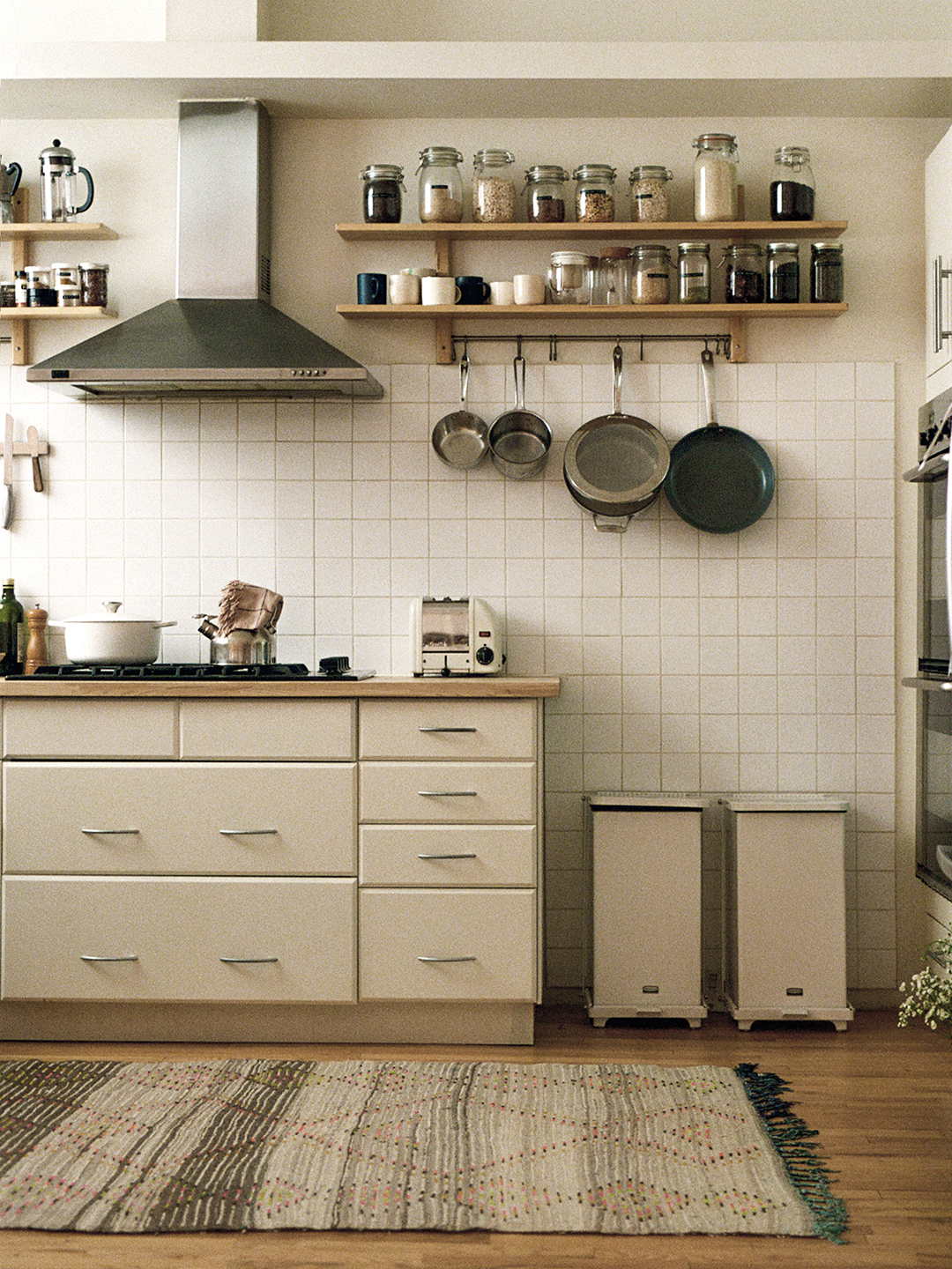 white kitchen with two side-by-side trash cans