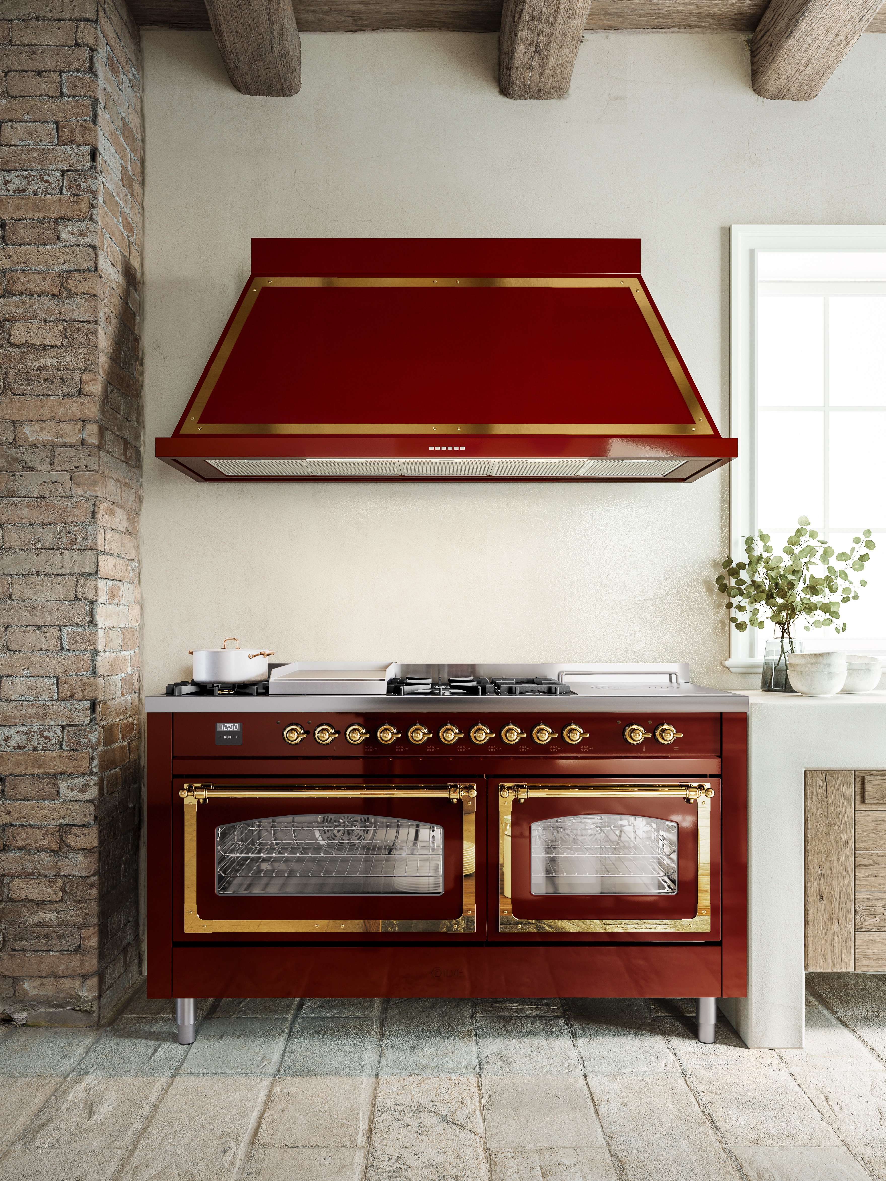 Glossy red kitchen stove with gold trim accents in old Italian barn-like setting.
