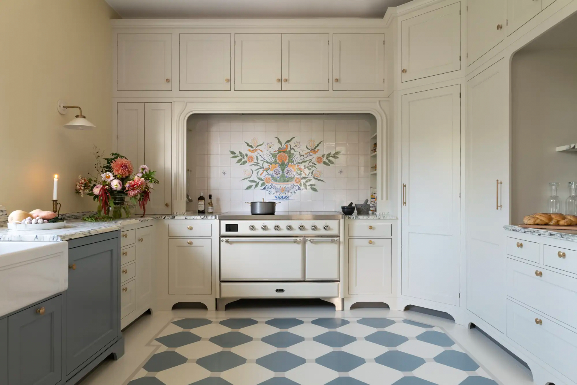 White stove and kitchen cabinets with floral pattern tiled backsplash.