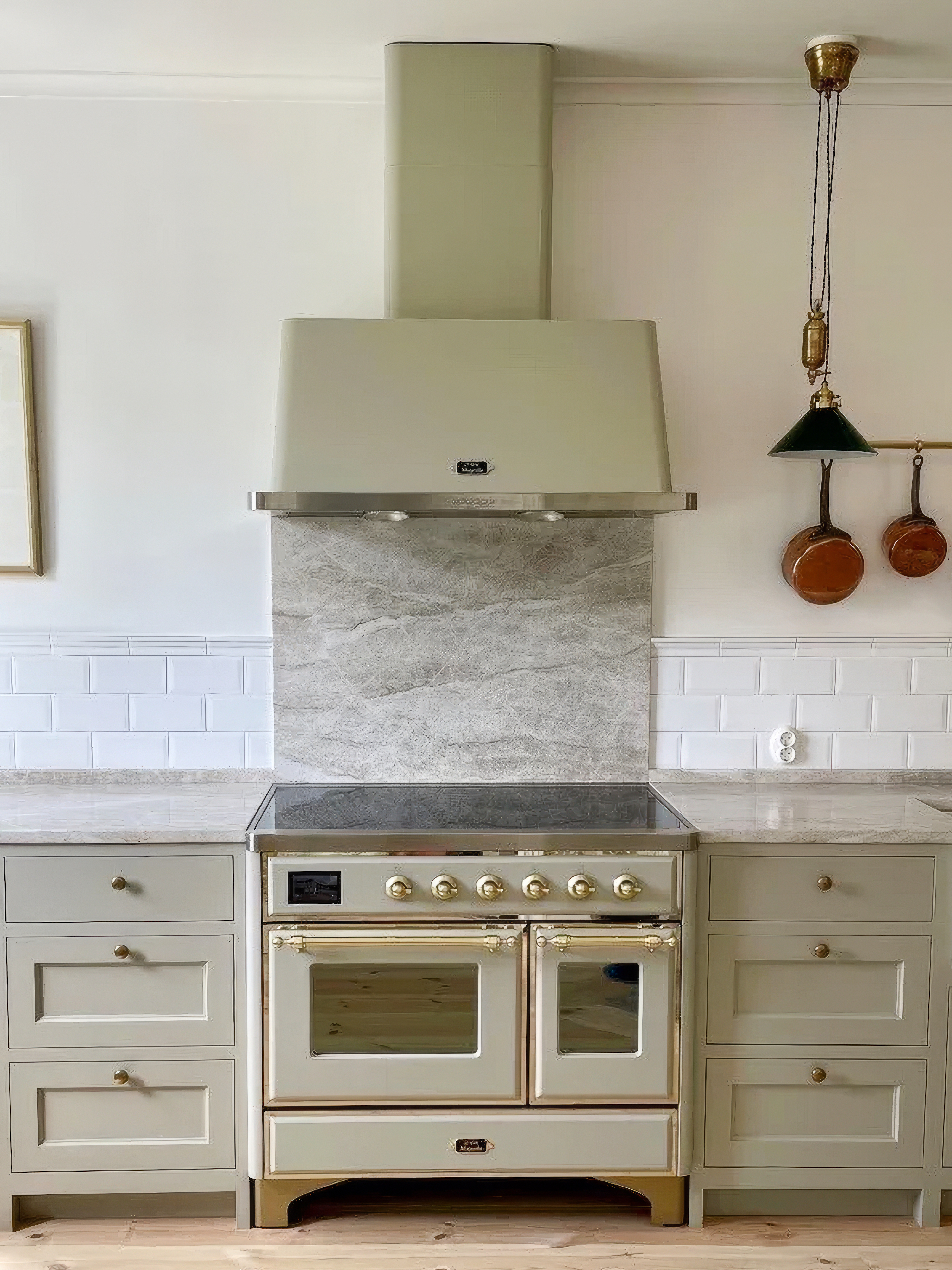 Sage green kitchen range and cabinets with grey stone backsplash.