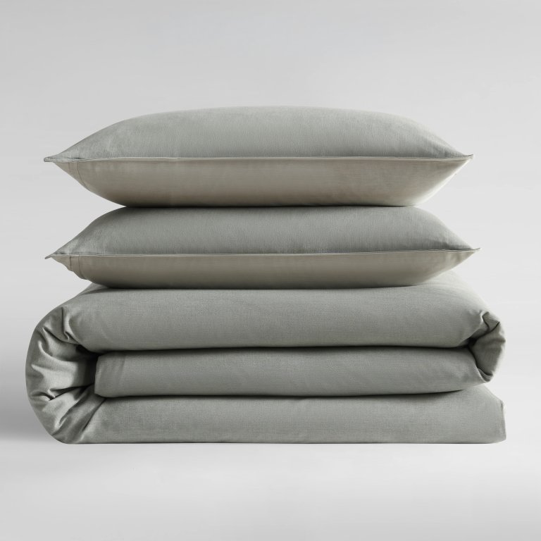  Stack of folded light green sheets against white background.