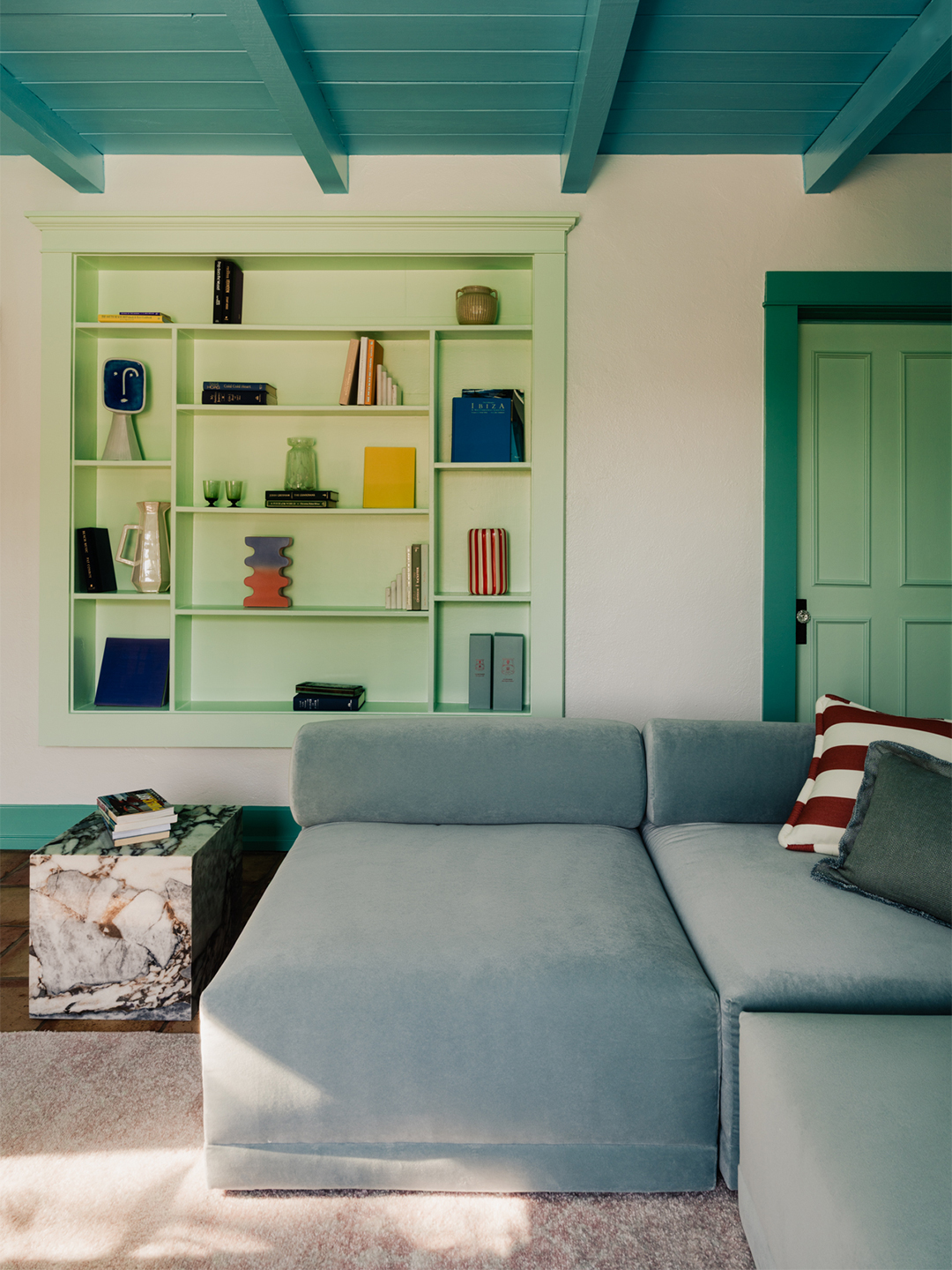 blue sofa, mint green bookcase