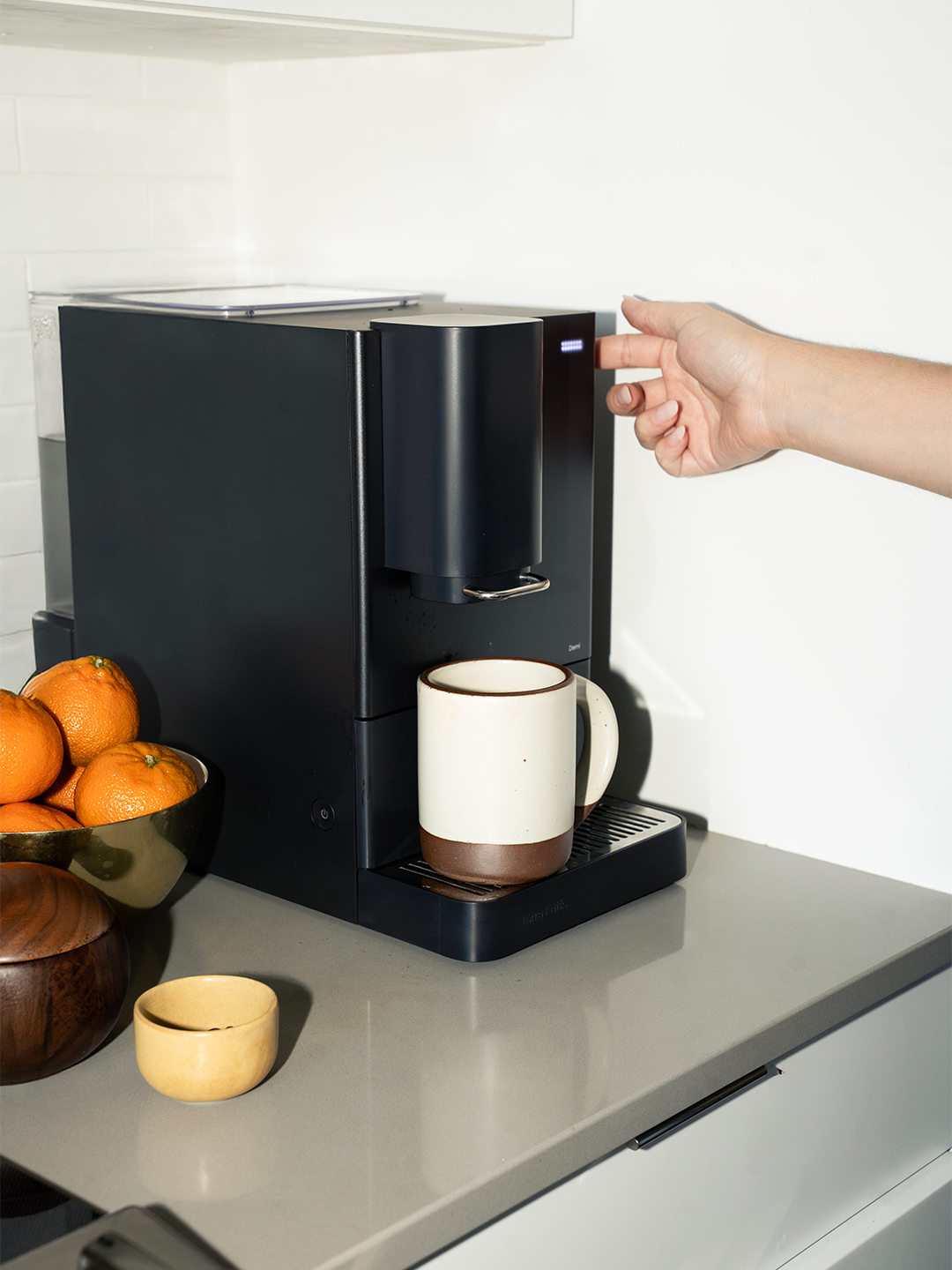hand turning on coffee maker