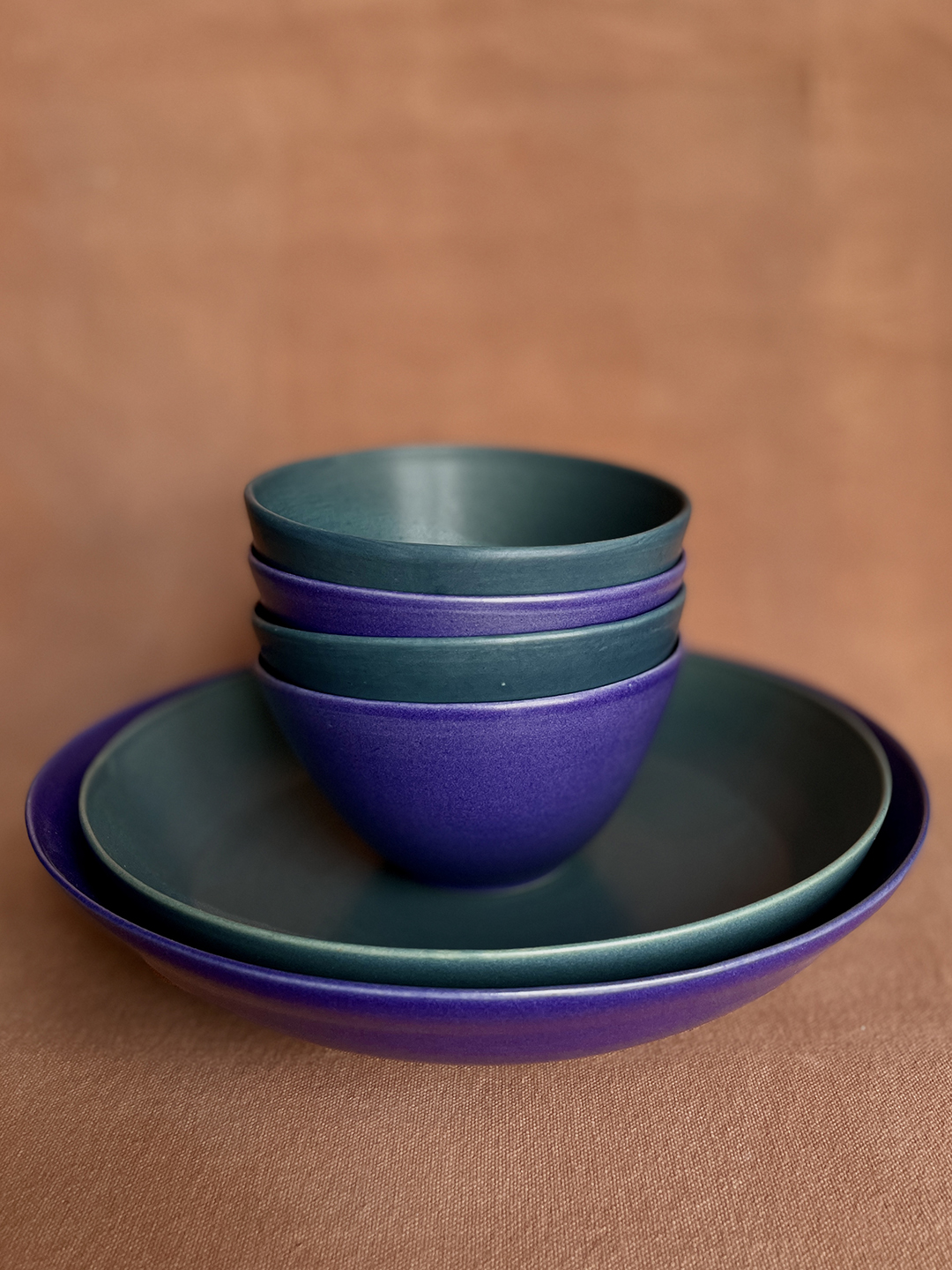 green and purple stack of ceramic bowls and plates