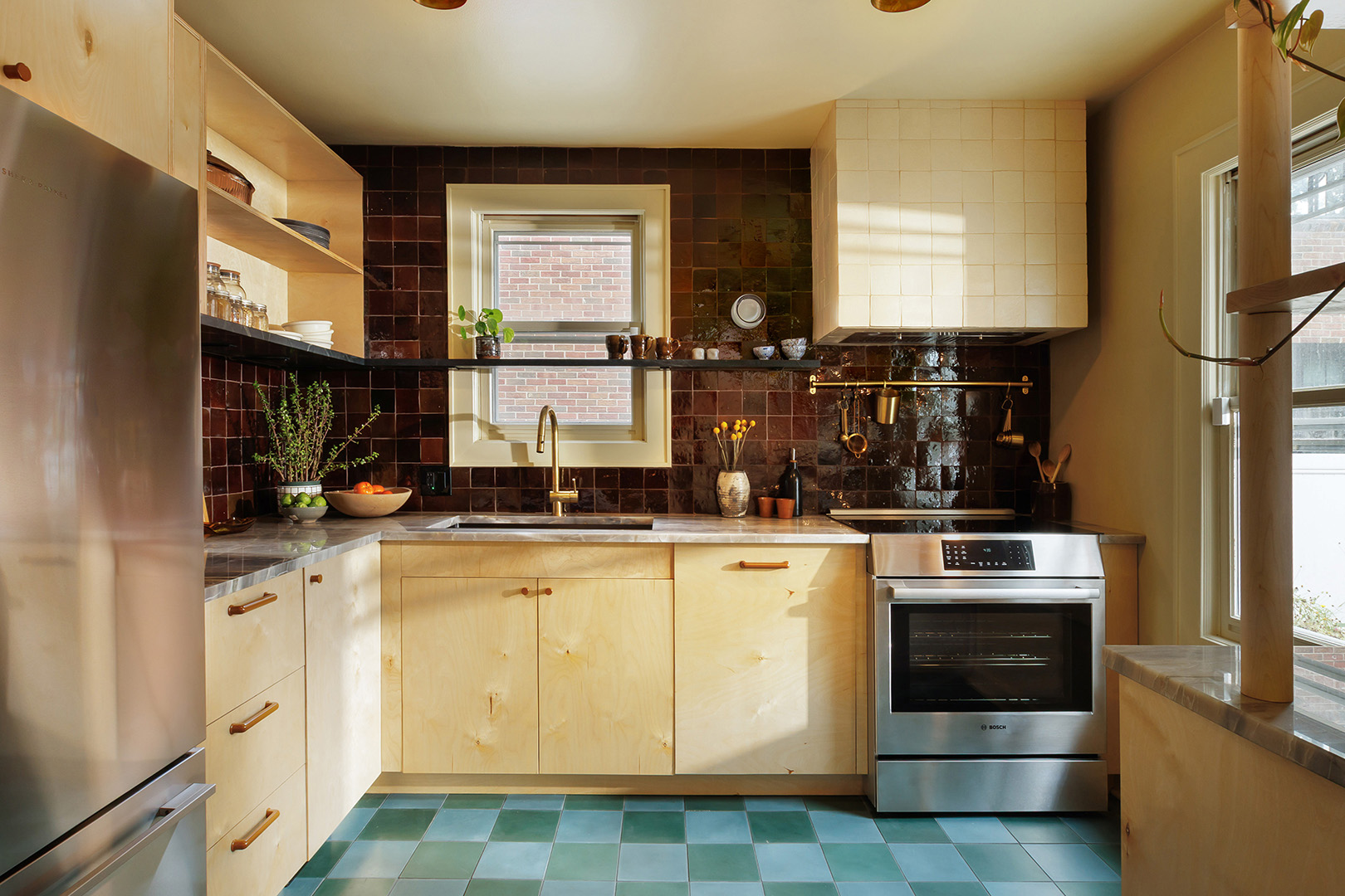 Kitchen with maroon tile, wood cabinets, teal floor.
