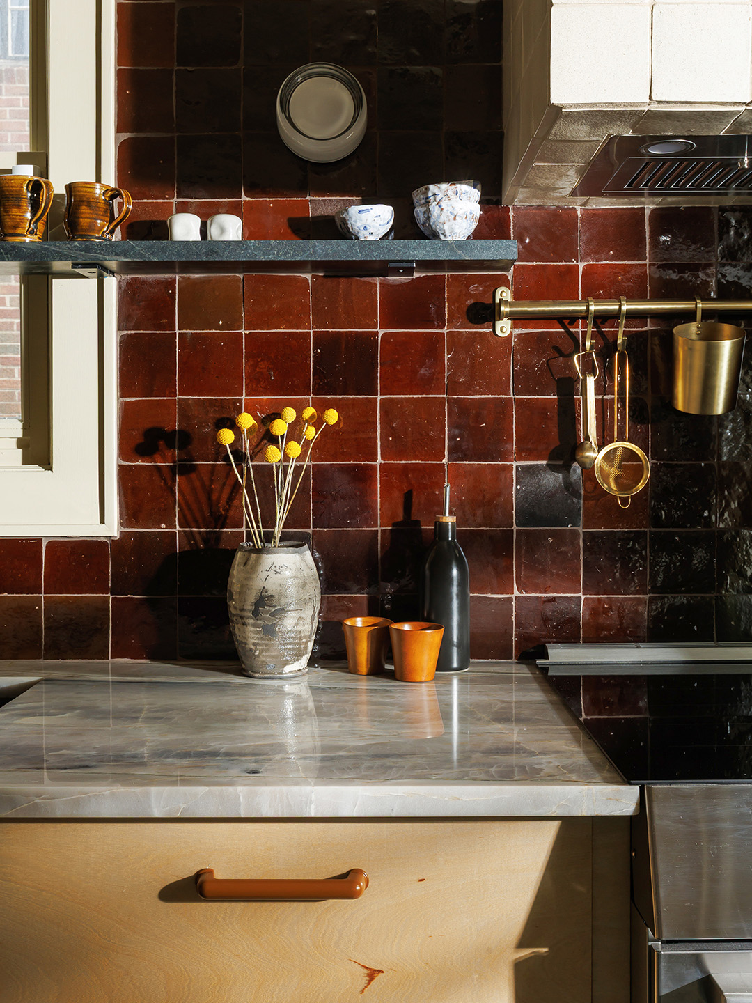 kitchen counter with maroon tile backsplash