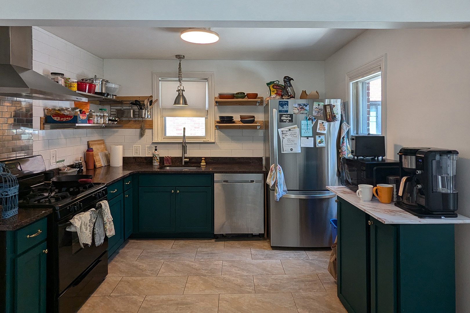 dark kitchen with white walls and teal cabinetry