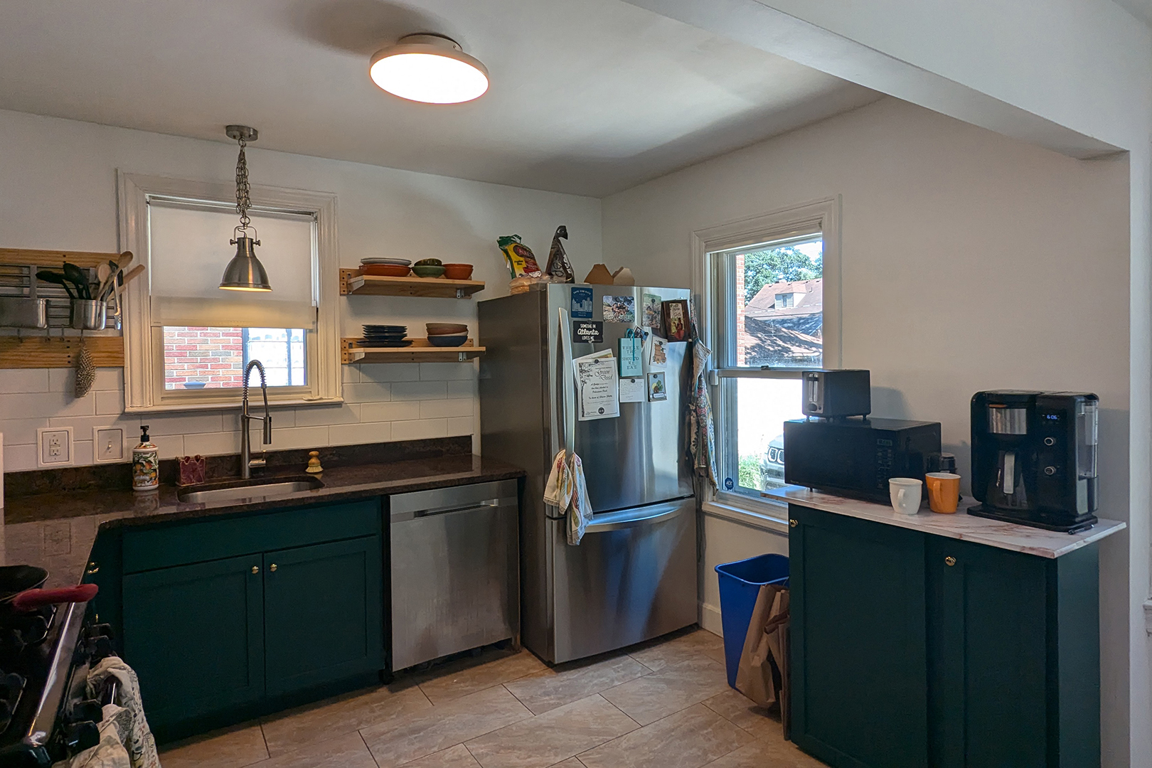 dark kitchen with fridge beside the big window