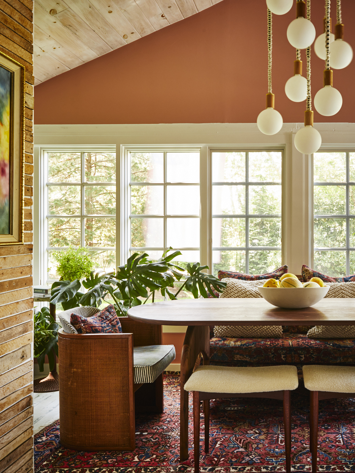 dining room with hanging lights above and orange wall behind