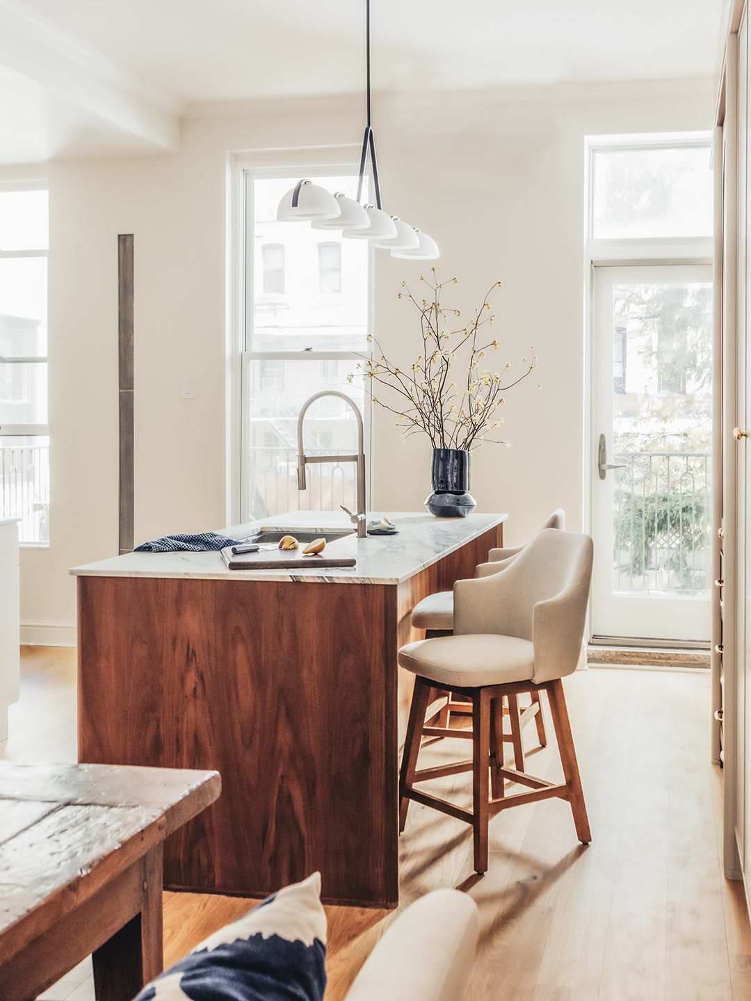 white kitchen with wood island and chairs
