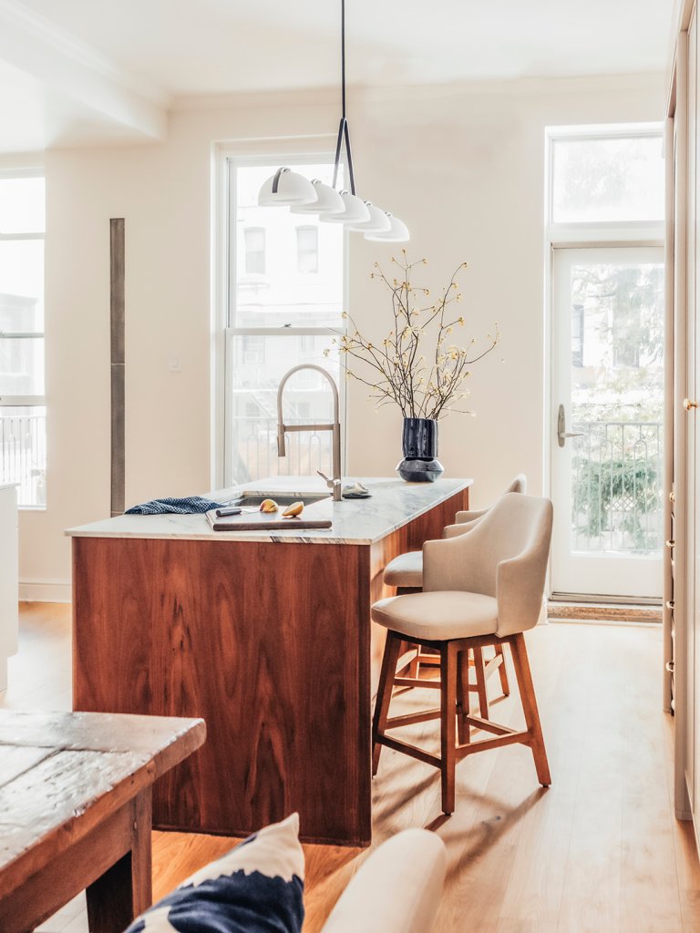 white kitchen with wood island and chairs