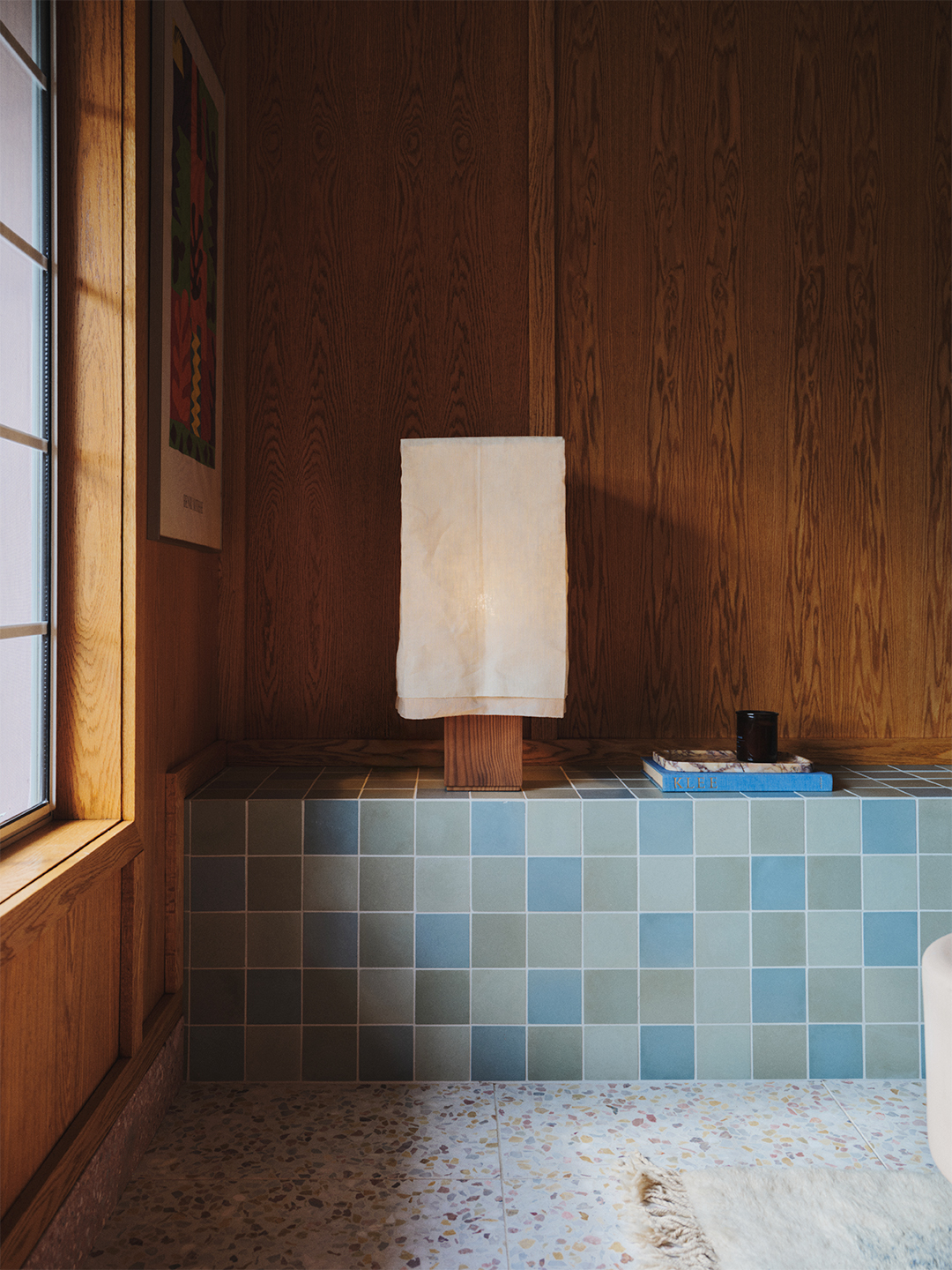 Paper lantern on blue tiled bench in a California living room.