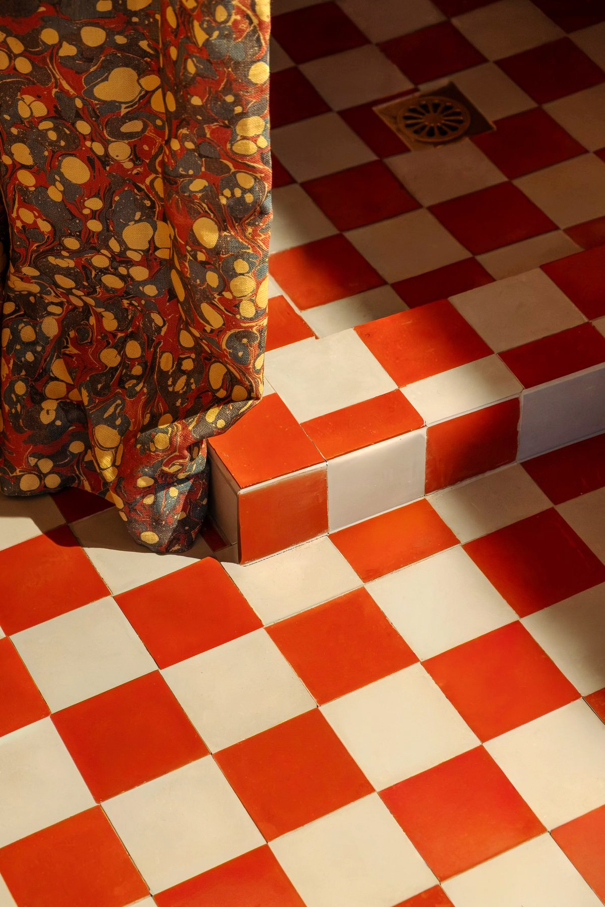 Detail of tomato red and light blue checkerboard bathroom tile.