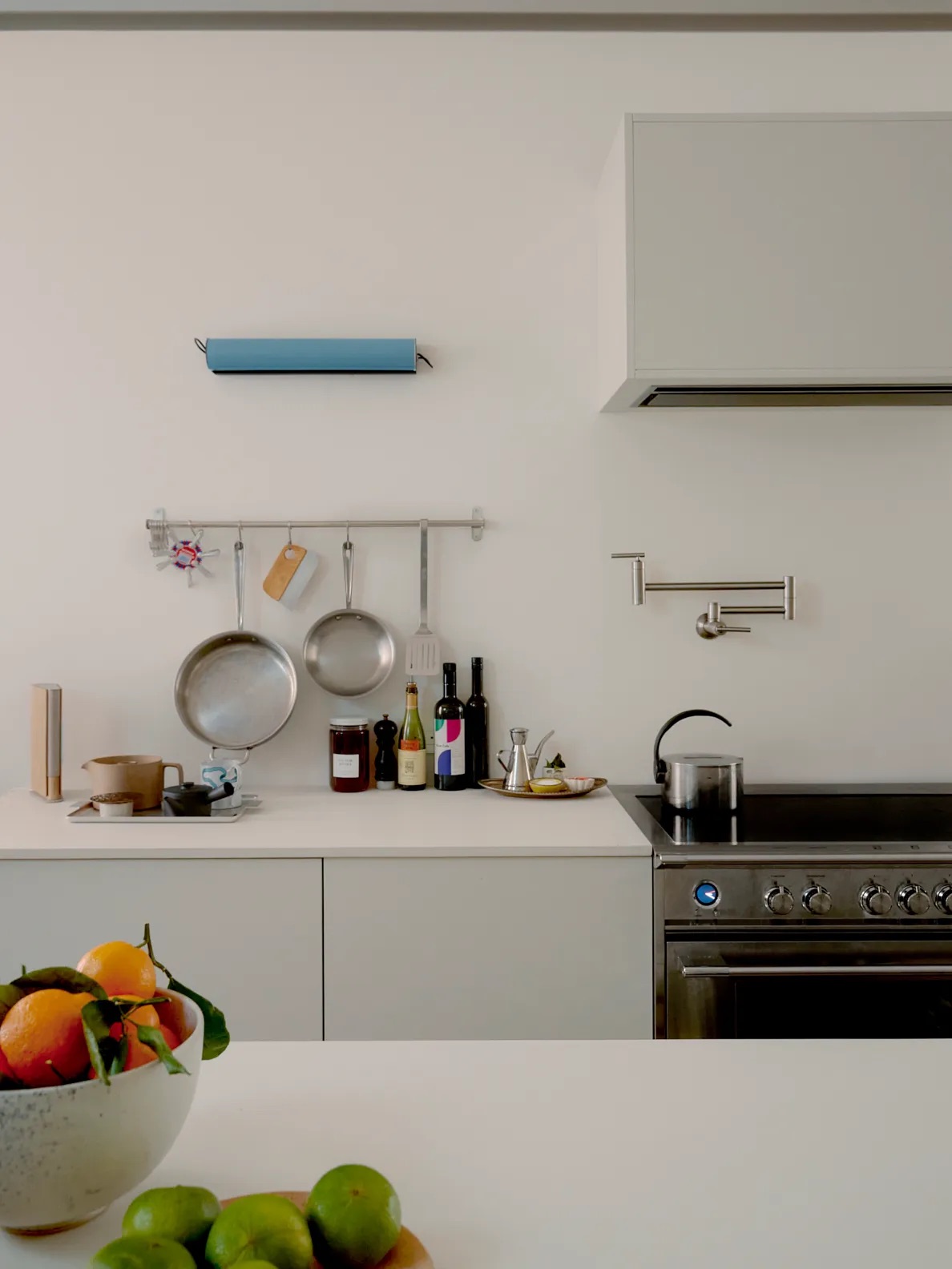 white kitchen with minimalist display of pans and condiments