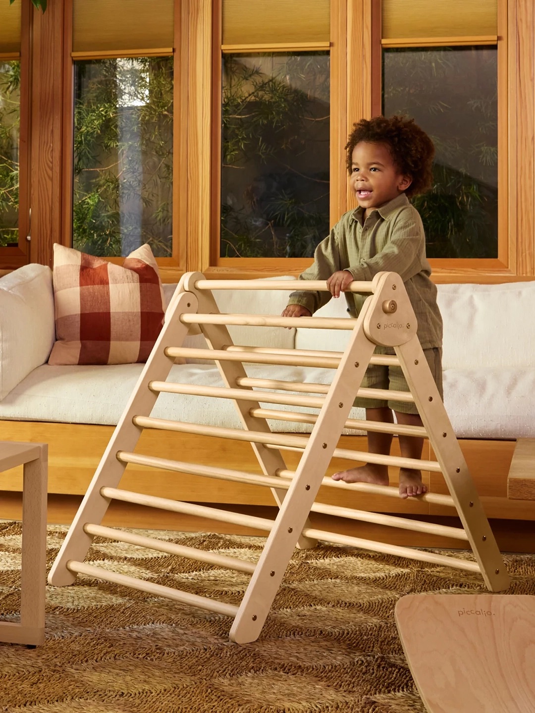 child on a wooden climbing frame indoors