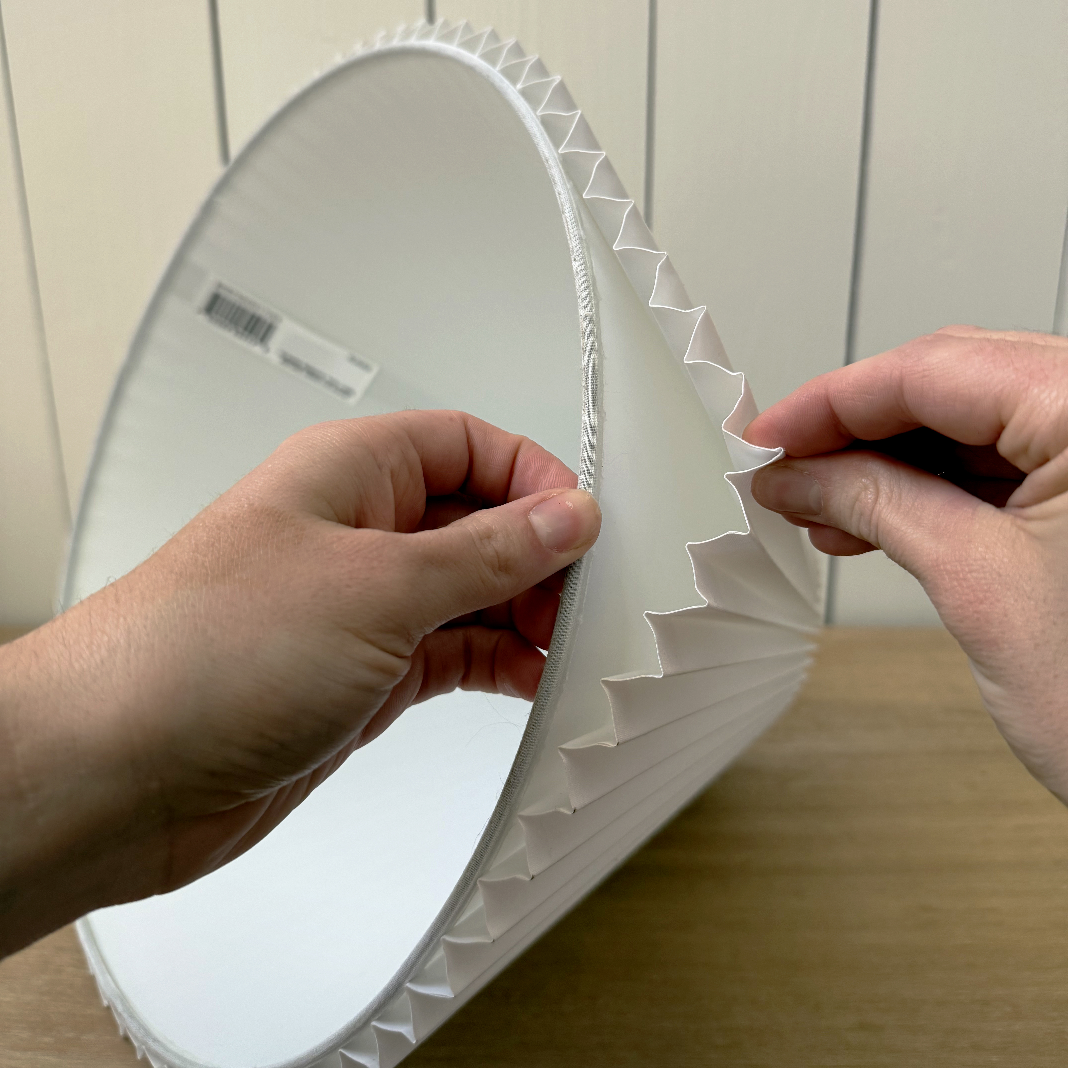 hands pulling apart two laters of pleated lampshade