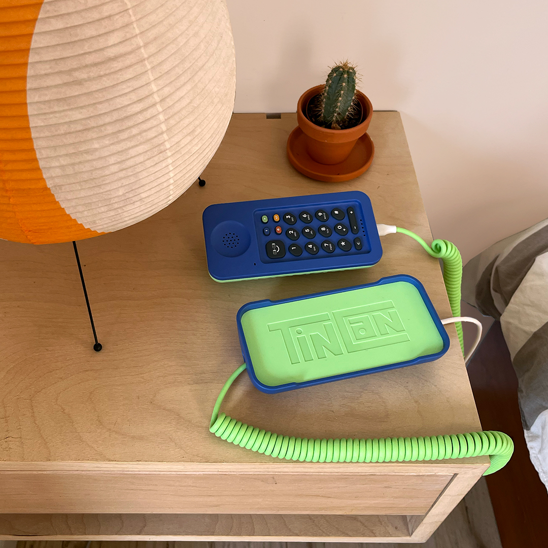 green landline phone beside a table lamp