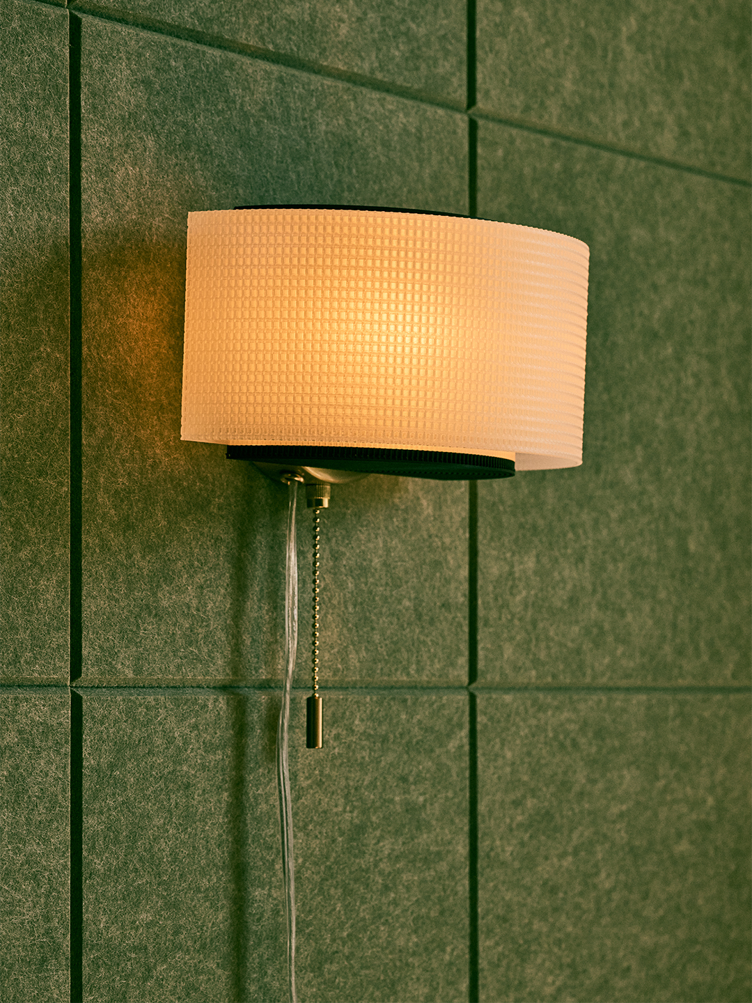 illuminated curved sconce with green background