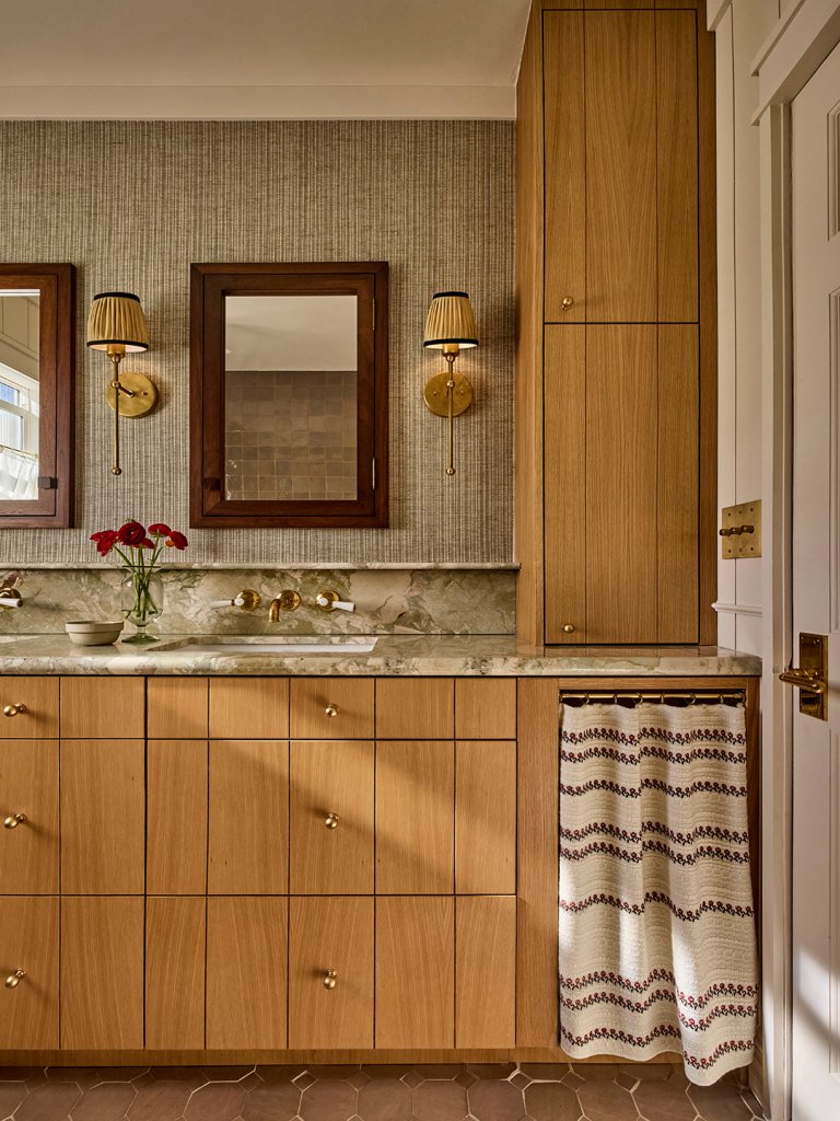 bathroom vanity with marble counter and wood cabinets