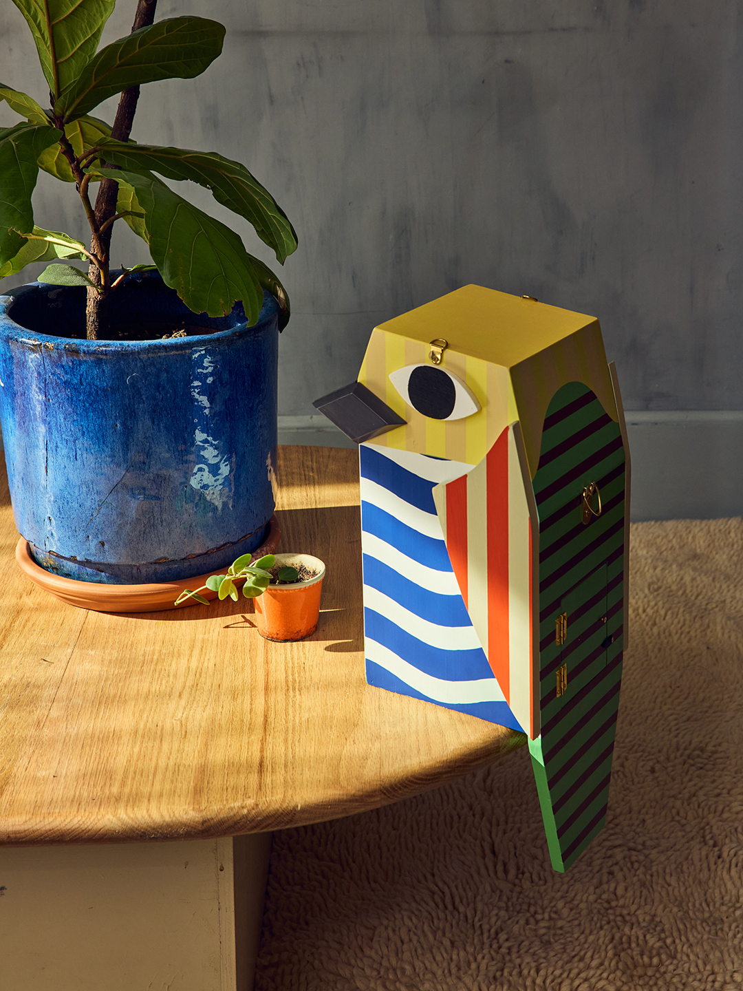colorful wooden birdhouse sitting on edge of table