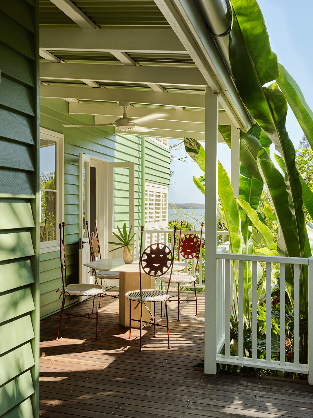 porch with green trees and dining table