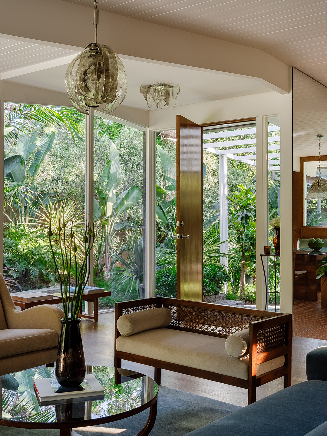 Living room with large windows and lots of greenery outside