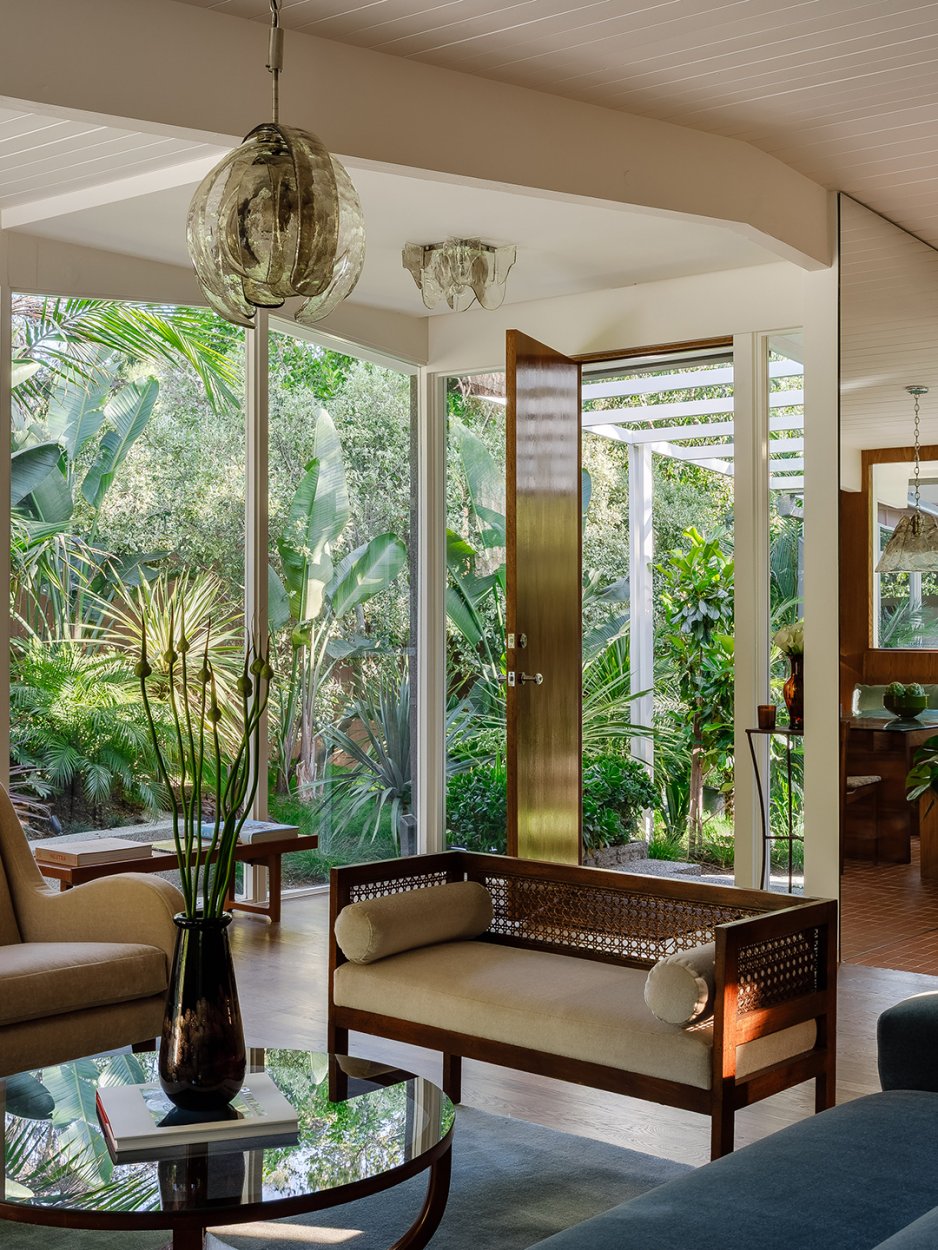 Living room with large windows and lots of greenery outside