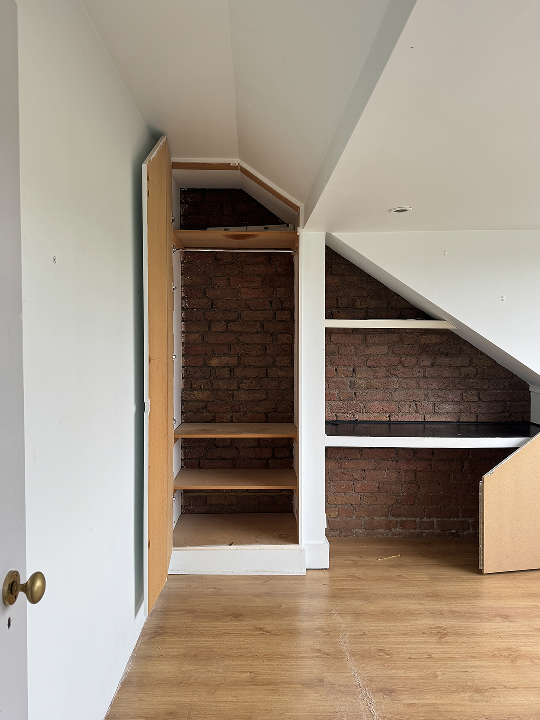 room with open shelving and brick wall