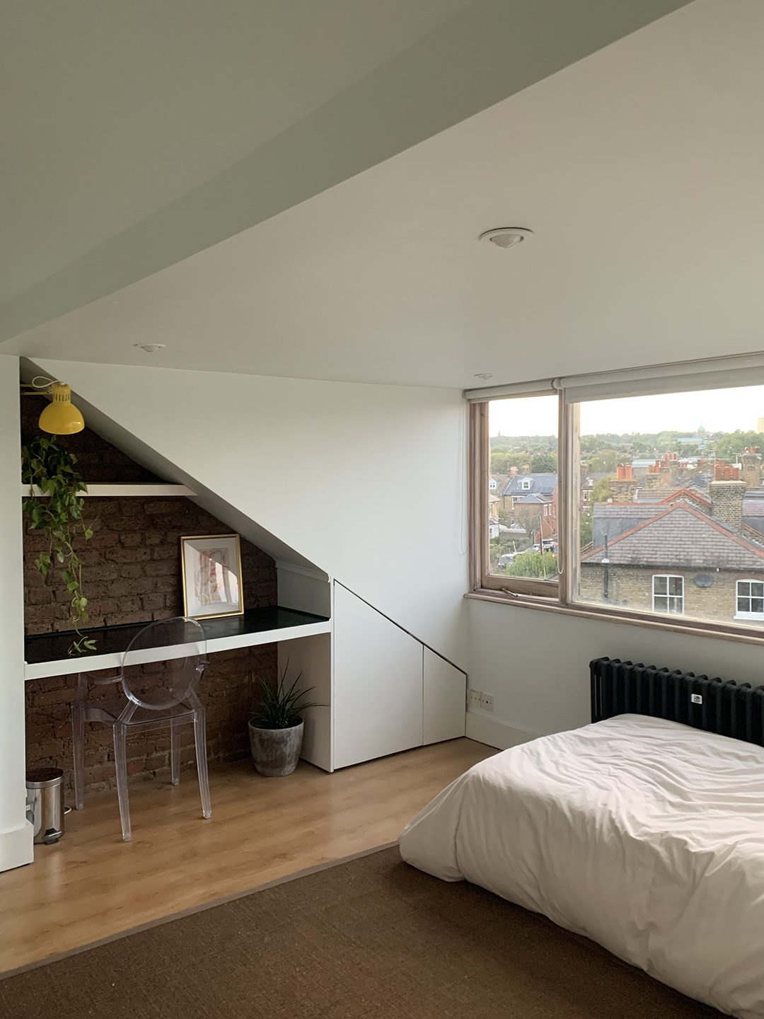 room with desk nook and white bed