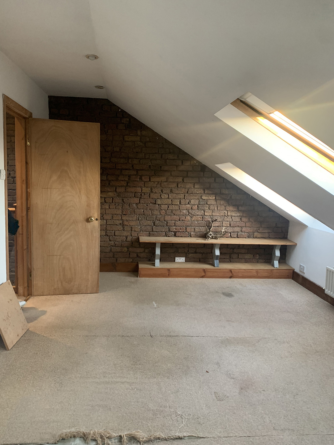 room with angled ceiling and brick wall