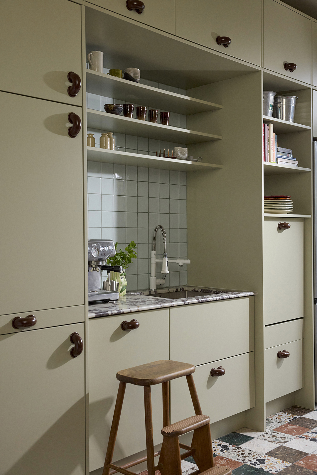 kitchen with sage-green cabinets and blue tile