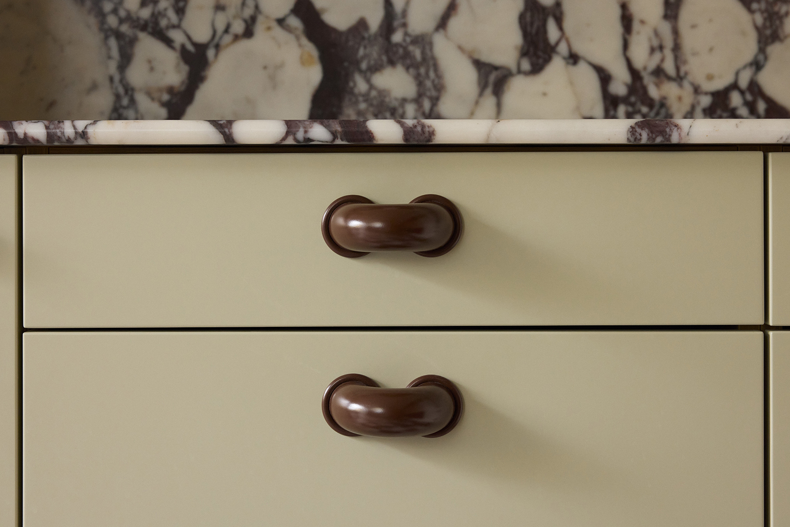 sage green cabinets with thick macaroni-shaped handles