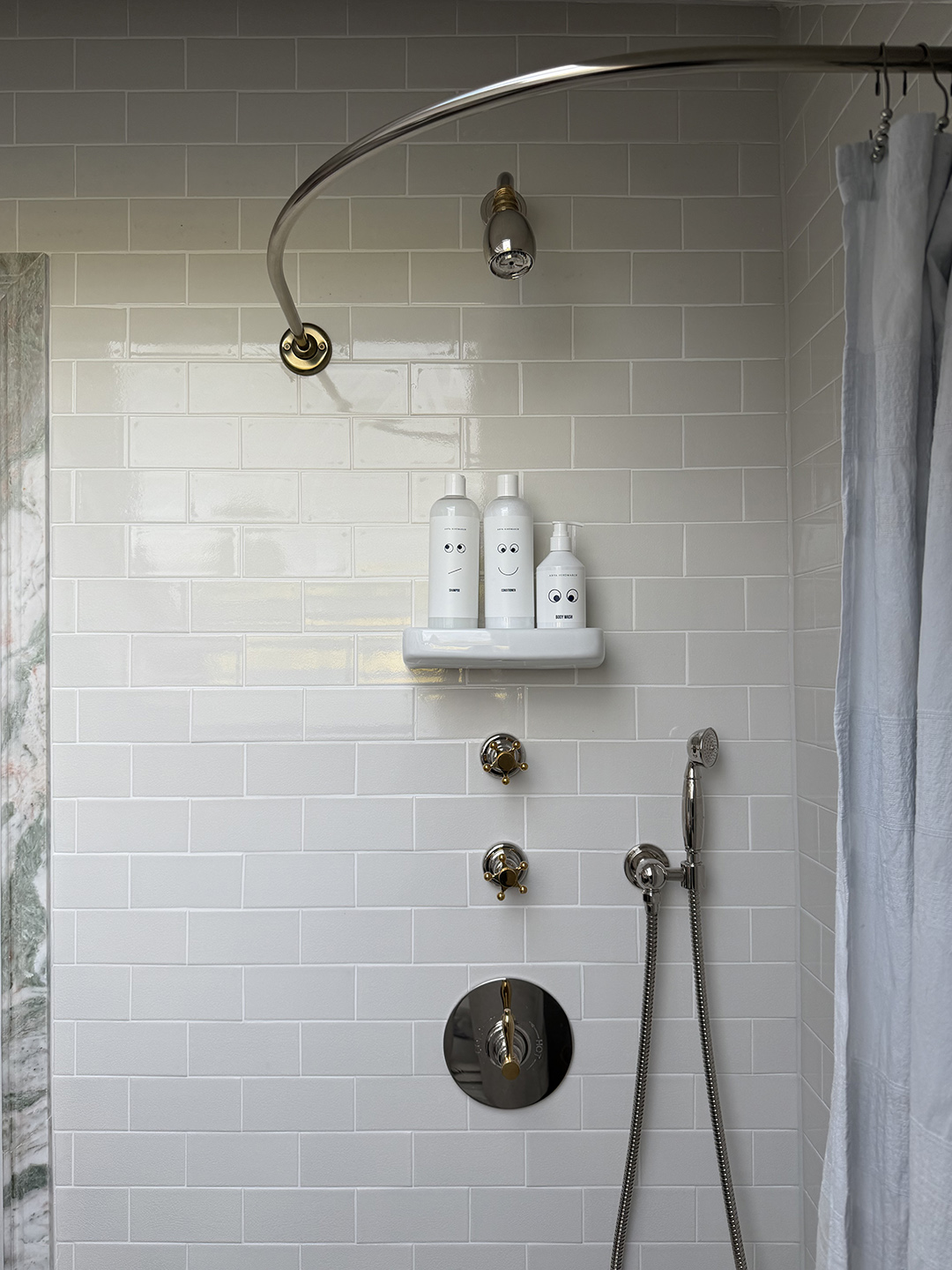 shower with white tiles and silver fixtures