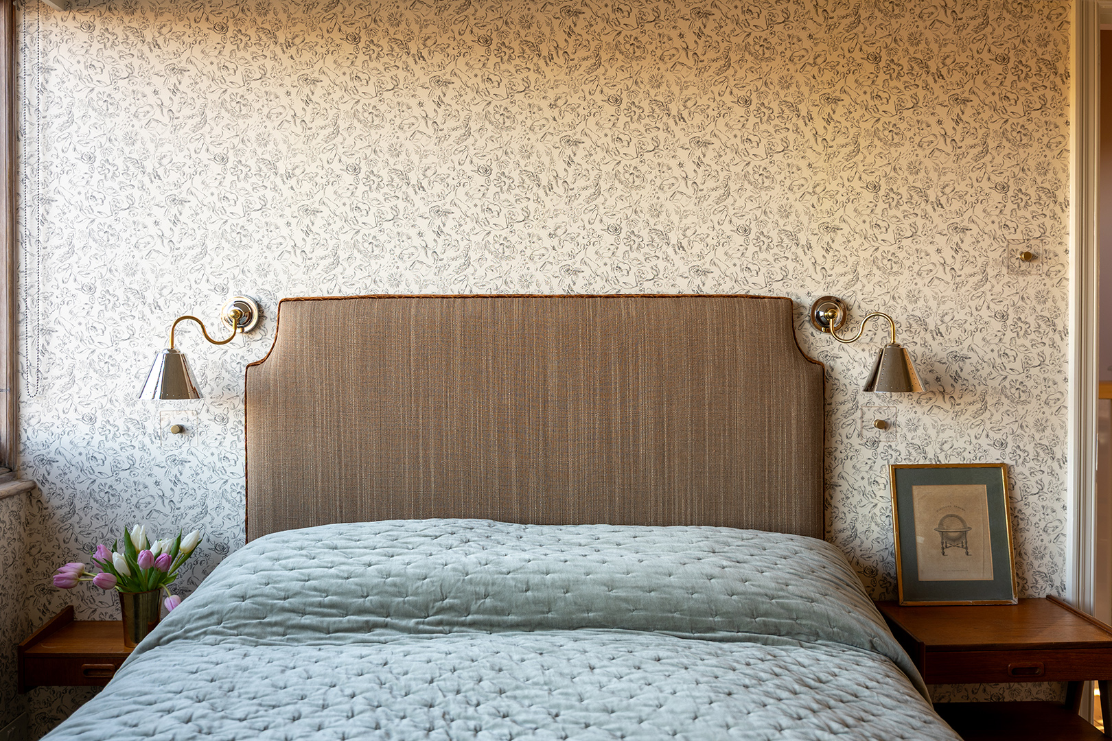 wallpapered guest room with bed and headboard