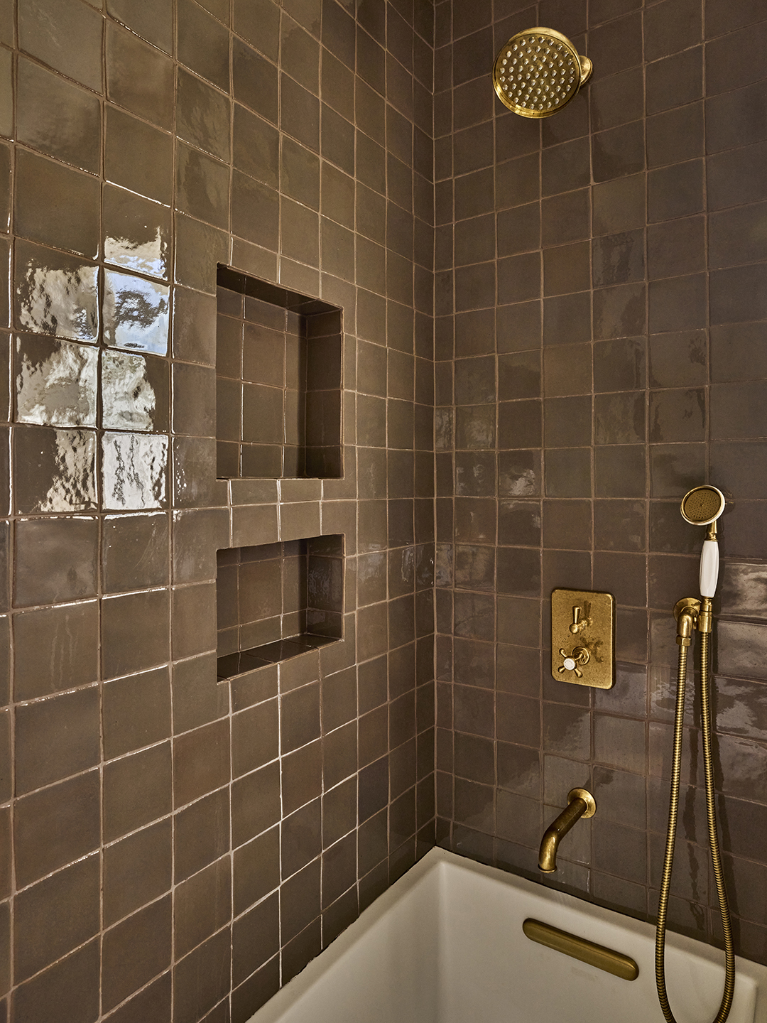 tiled shower with gold faucet details
