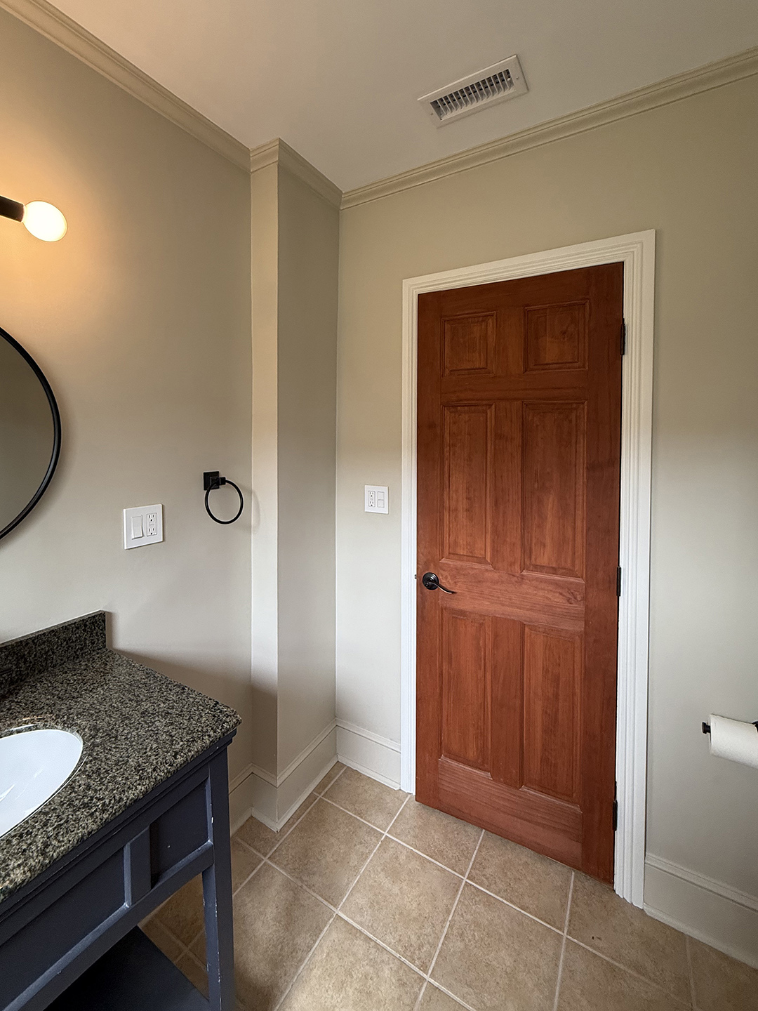 bathroom with grey walls and wood door