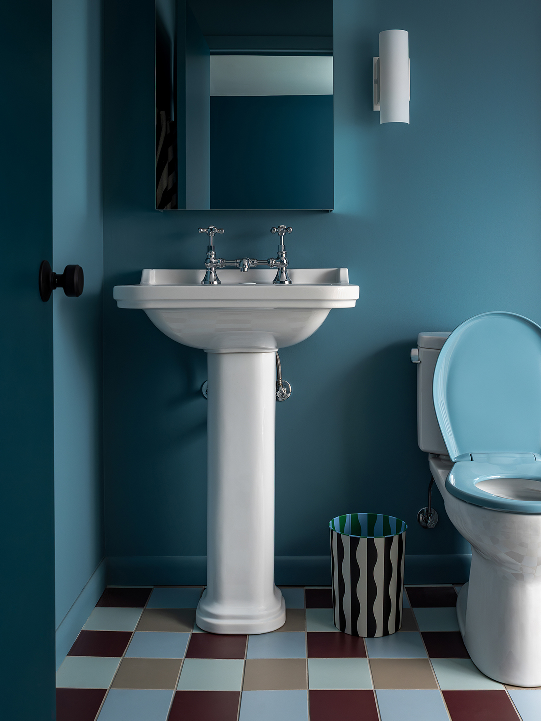 blue bathroom with white sink and tiled floor