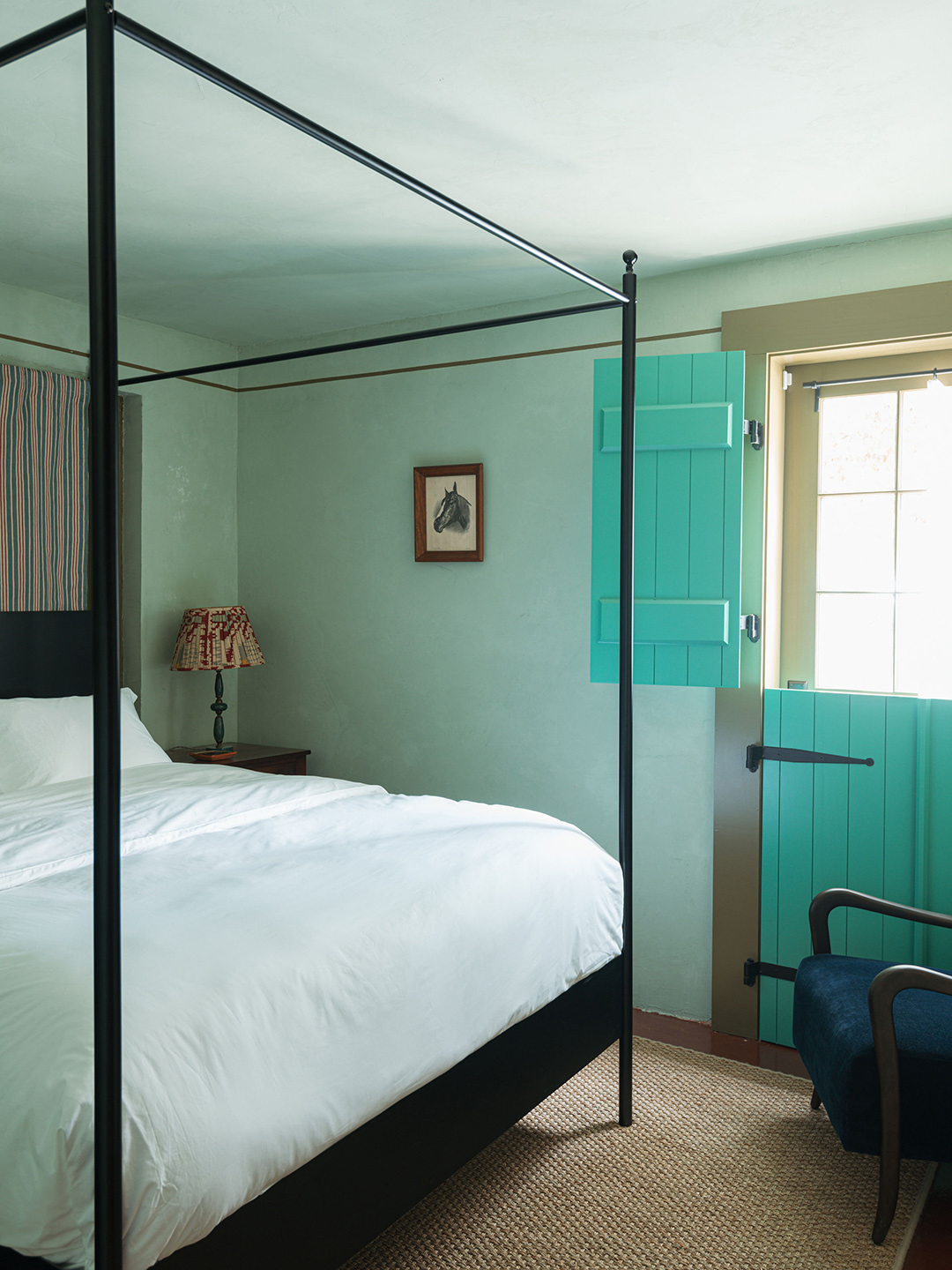 bedroom with canopy bed and teal walls and shutters