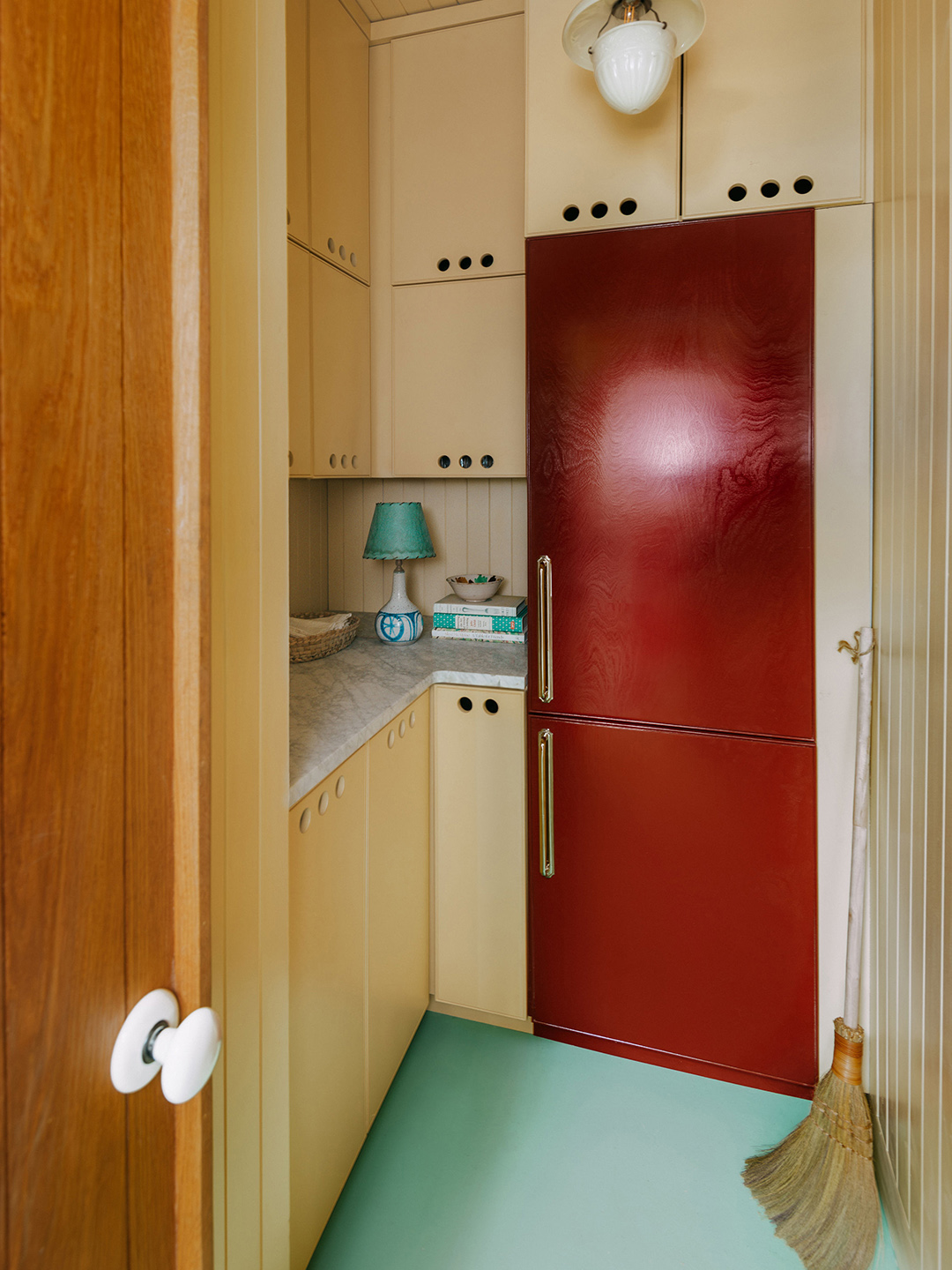 small yellow kitchen with red fridge