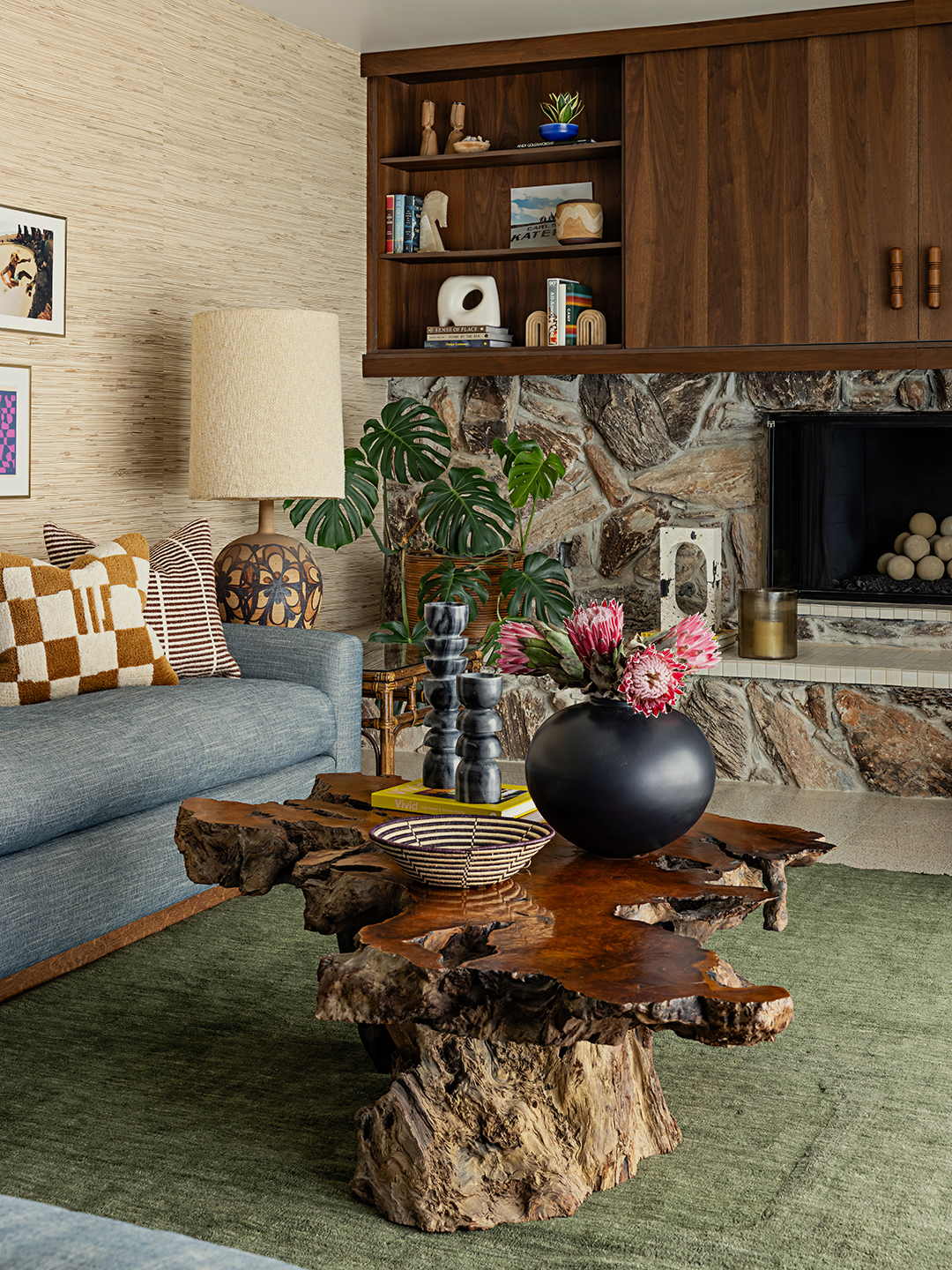 living room with raw wood coffee table and stone fireplace
