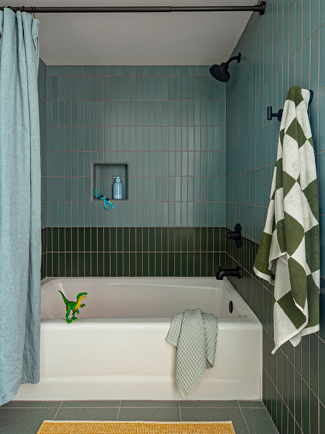 bathroom with white tub and green and blue tile