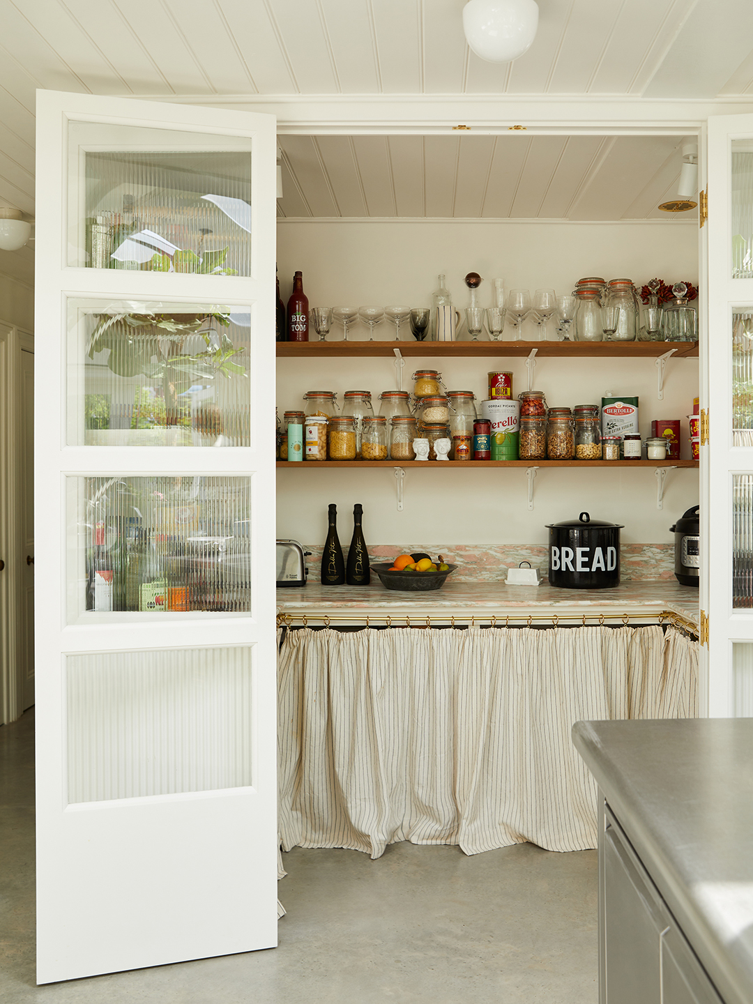 white pantry area with open shelving and skirted bottom cupboards