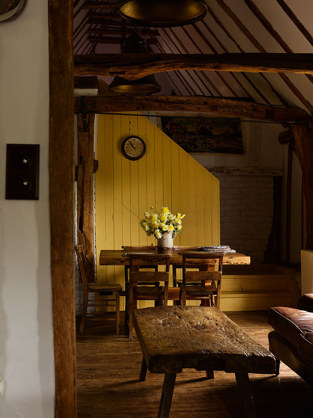cottage dining area with yellow wall and wood furniture