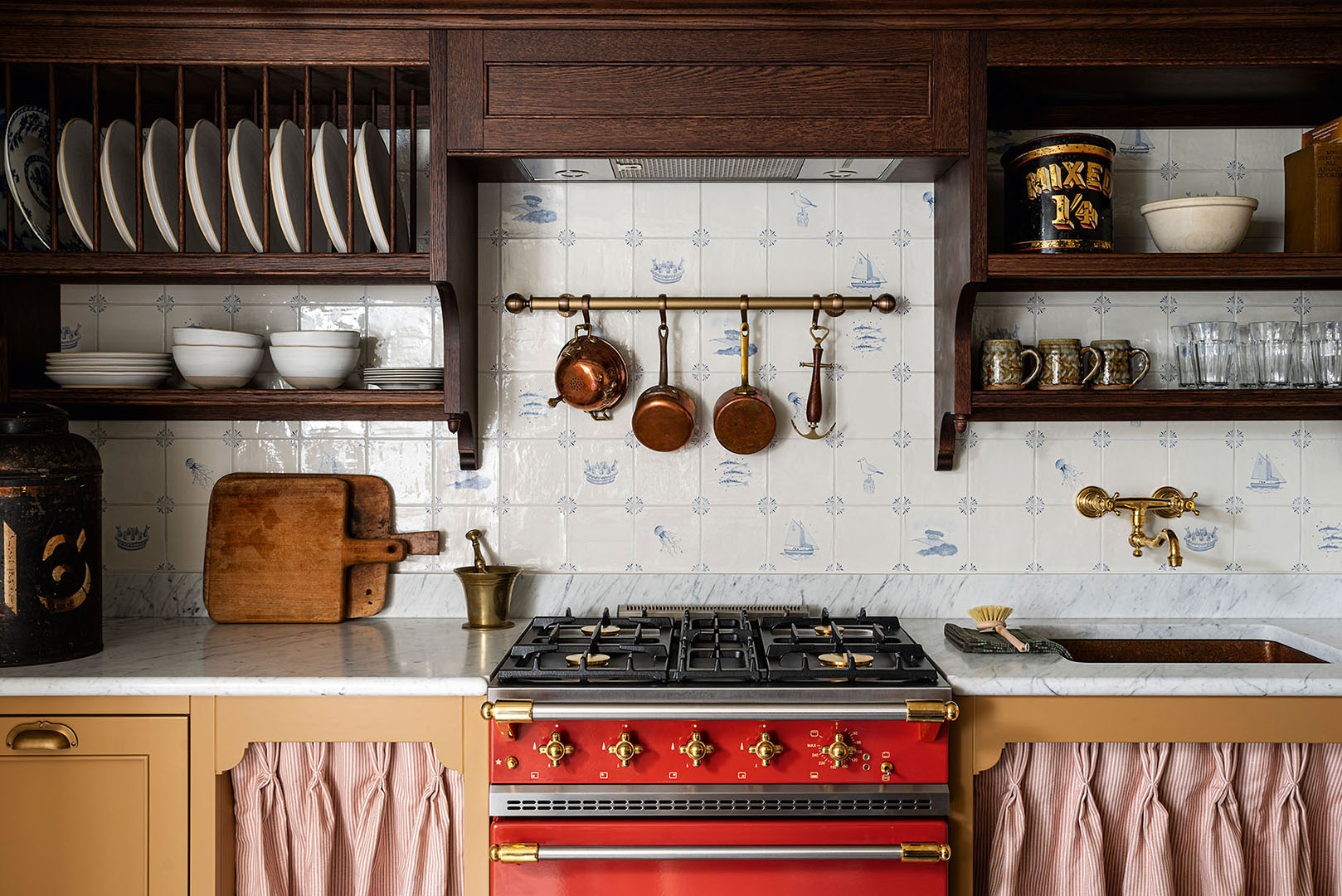 cottage kitchen with red stove and wooden shelving